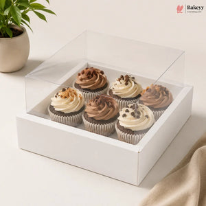 Clear box with cupcakes on a light surface, featuring the Bakeyy brand.