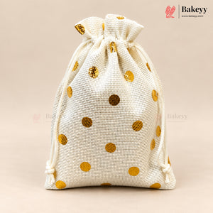 An off-white burlap drawstring bag with metallic gold polka dots, shown on a solid beige background. The Bakeyy brand logo is visible in the top right corner.
