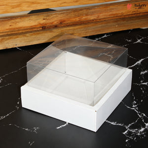 White jewelry box with clear lid on a black marble surface, with 'Bakeey' brand visible.