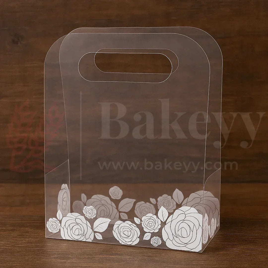Clear cake box with floral design on a wooden background, featuring the brand 'Bakeyy'.