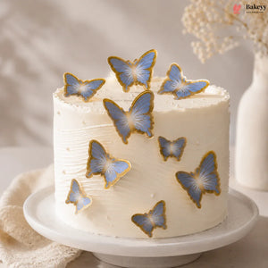 White cake with blue butterfly decorations on a neutral background