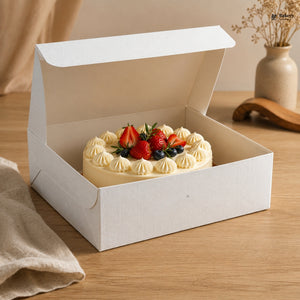 Small cake with strawberries and cream in a white box on a wooden table.