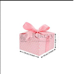 Pink gift box with white polka dots and a pink ribbon, featuring dimensions on a white background.