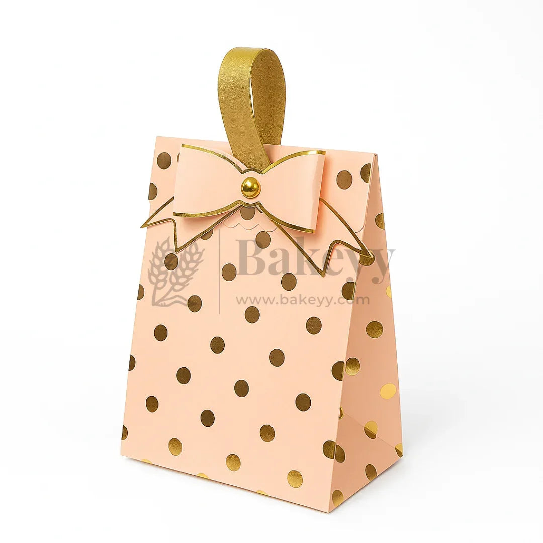Pink gift bag with gold polka dots and a bow, featuring the brand 'Bakeyy'.