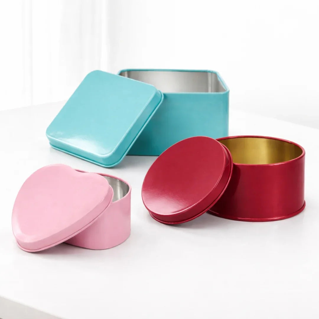Colorful plain tin boxes for gift packaging and hampers on white table, Bakeyy wholesale.