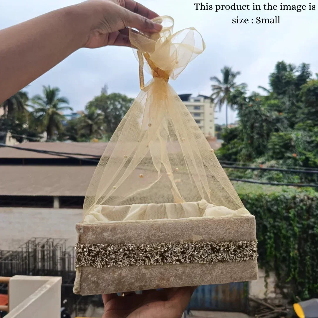 Small beige decorative net basket with gold accents, ideal for gift packaging or hampers, outdoors