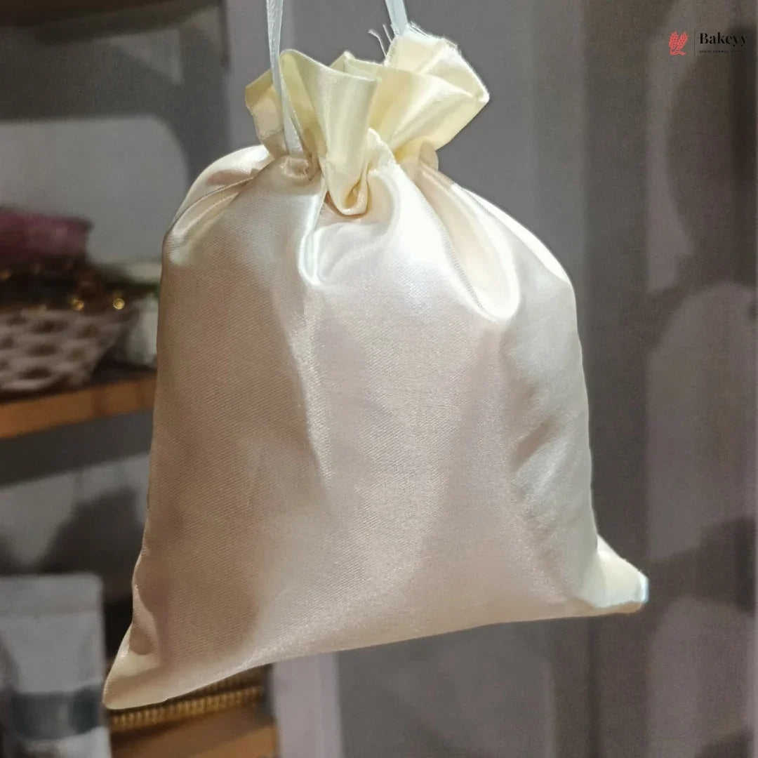 Beige drawstring bag hanging against a blurred indoor background