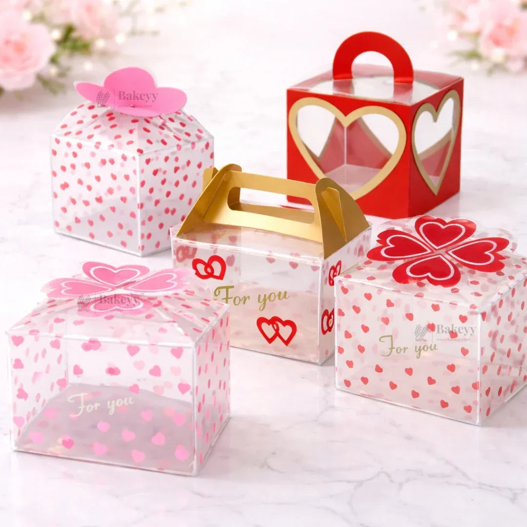 Assorted heart-themed transparent gift boxes with handles, ideal for bakery packaging from Bakeyy.