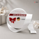 Roll of white decorative ribbon with a red bow design on a gray background
