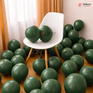 White chair surrounded by green balloons in a room with curtains and a wooden floor.