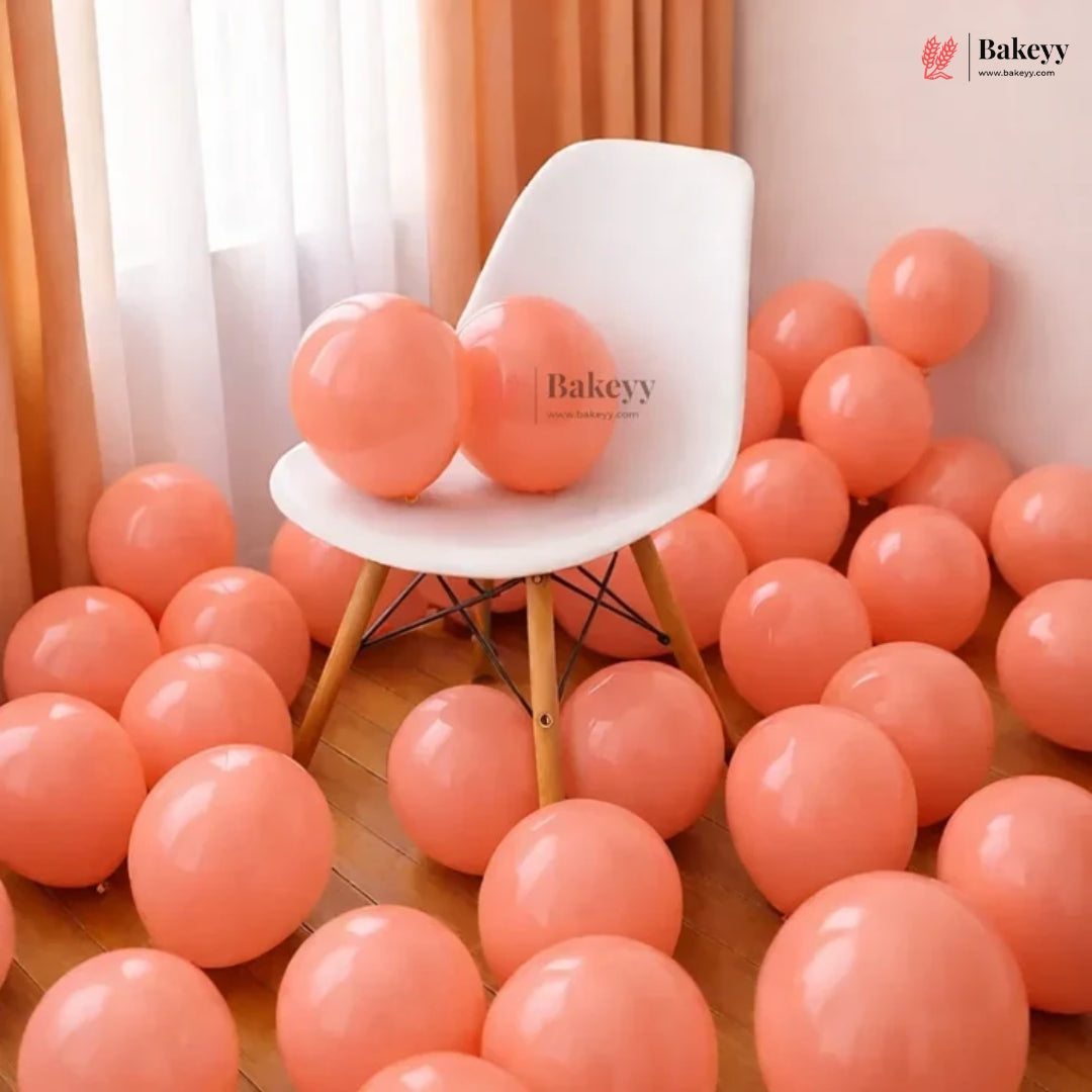 White chair surrounded by pink balloons in a room with curtains.