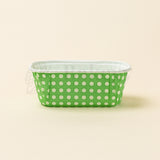 Green container with white polka dots on a beige background