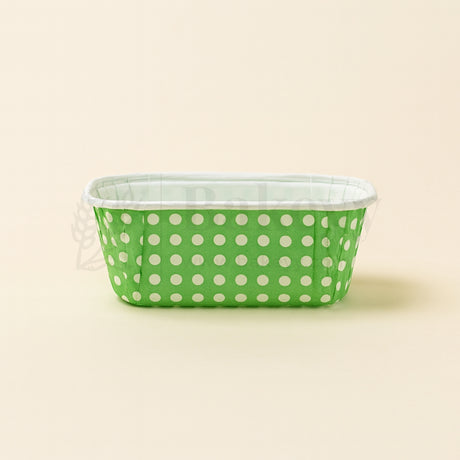 Green container with white polka dots on a beige background