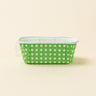 Green container with white polka dots on a beige background