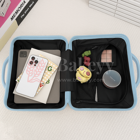 Blue travel case with compartments containing a phone, books, a toy, and a small round item on a light gray surface.