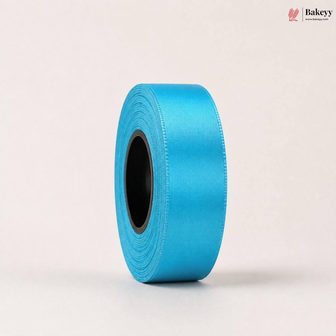 Roll of blue satin ribbon on a light beige background