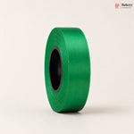 Roll of green ribbon on a beige background with 'Bakeyy' branding.