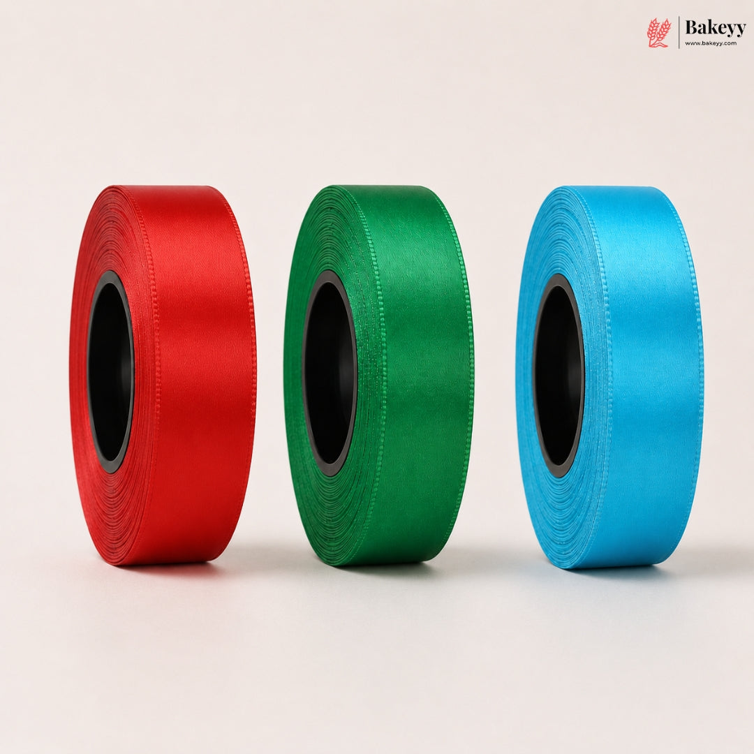 Three rolls of ribbon in red, green, and blue on a light beige background.