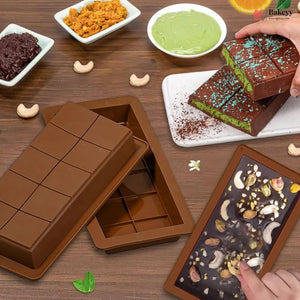 Chocolate mold with finished chocolate bars on a wooden table.