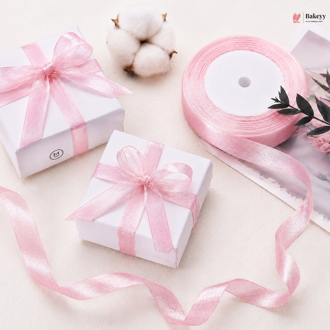 Two white gift boxes with pink ribbons on a light background