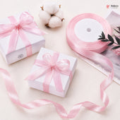 Two white gift boxes with pink ribbons on a light background
