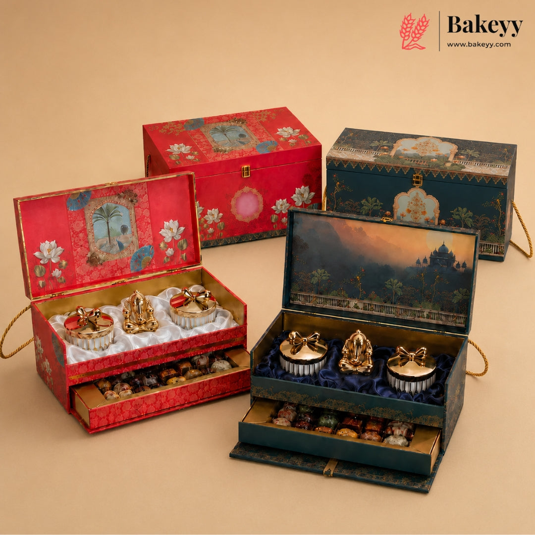 Four decorative gift boxes for sweets and tea, shown open and closed on a beige background. The boxes are red and dark blue-green with ornate floral and scenic illustrations, and the open boxes reveal gold-toned tea sets and assorted chocolates inside.