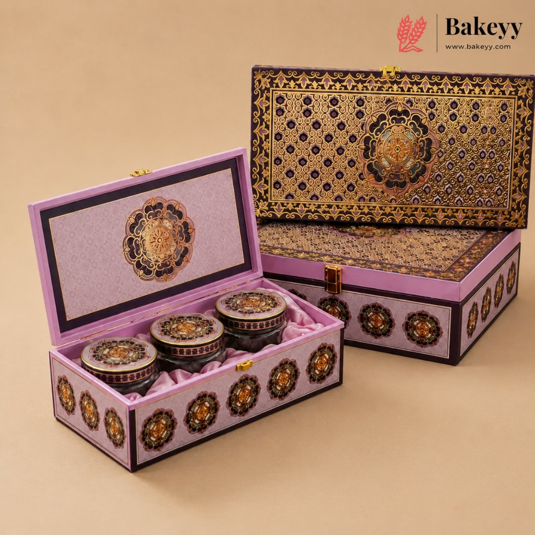 An ornate rectangular gift box set with three small round jars inside, shown open and closed on a warm beige background. The packaging features intricate gold, black, and purple floral patterns, and the Bakeey brand logo is visible in the top right corner.