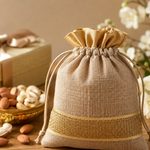 Beige drawstring bag on a wooden surface with nuts and flowers in the background