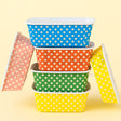 Set of colorful polka dot containers on a yellow background