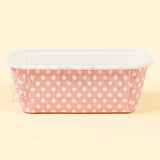Pink container with white polka dots on a beige background