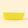 Yellow container with white polka dots on a beige background