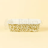 Clear plastic container with gold floral pattern on a beige background