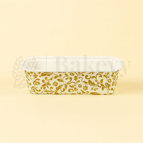 Clear plastic container with gold floral pattern on a beige background