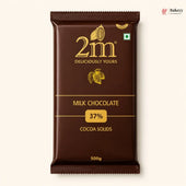 A 500g package of 2m Milk Chocolate 37% Cocoa Solids, shown against a light cream background. The packaging is dark brown with gold lettering and cocoa illustrations.