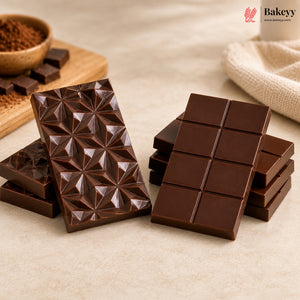 Two chocolate bars, one with geometric pattern and the other with square pieces, on a light surface with 'Bakeyy' branding.