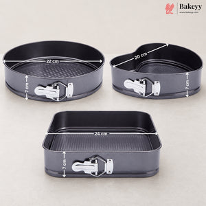 Three dark gray non-stick springform baking pans with white latch clasps, shown on a light beige background with overlaid dimension lines and text indicating 22 cm, 20 cm, and 24 cm diameters and 7 cm height. A Bakeey logo appears in the top right corner.