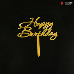 Gold metallic 'Happy Birthday' script cake topper on a black background, with a small Bakeyy logo in the top right corner.