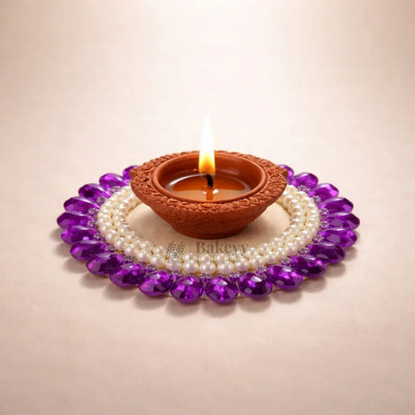 Clay diya lamp with flame, decorated with pearls and purple gemstones, Bakeyy.com