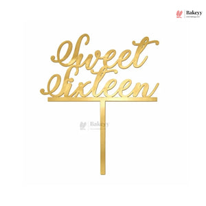 Gold metallic script cake topper reading 'Sweet Sixteen' with a single vertical stake, shown on a plain white background.