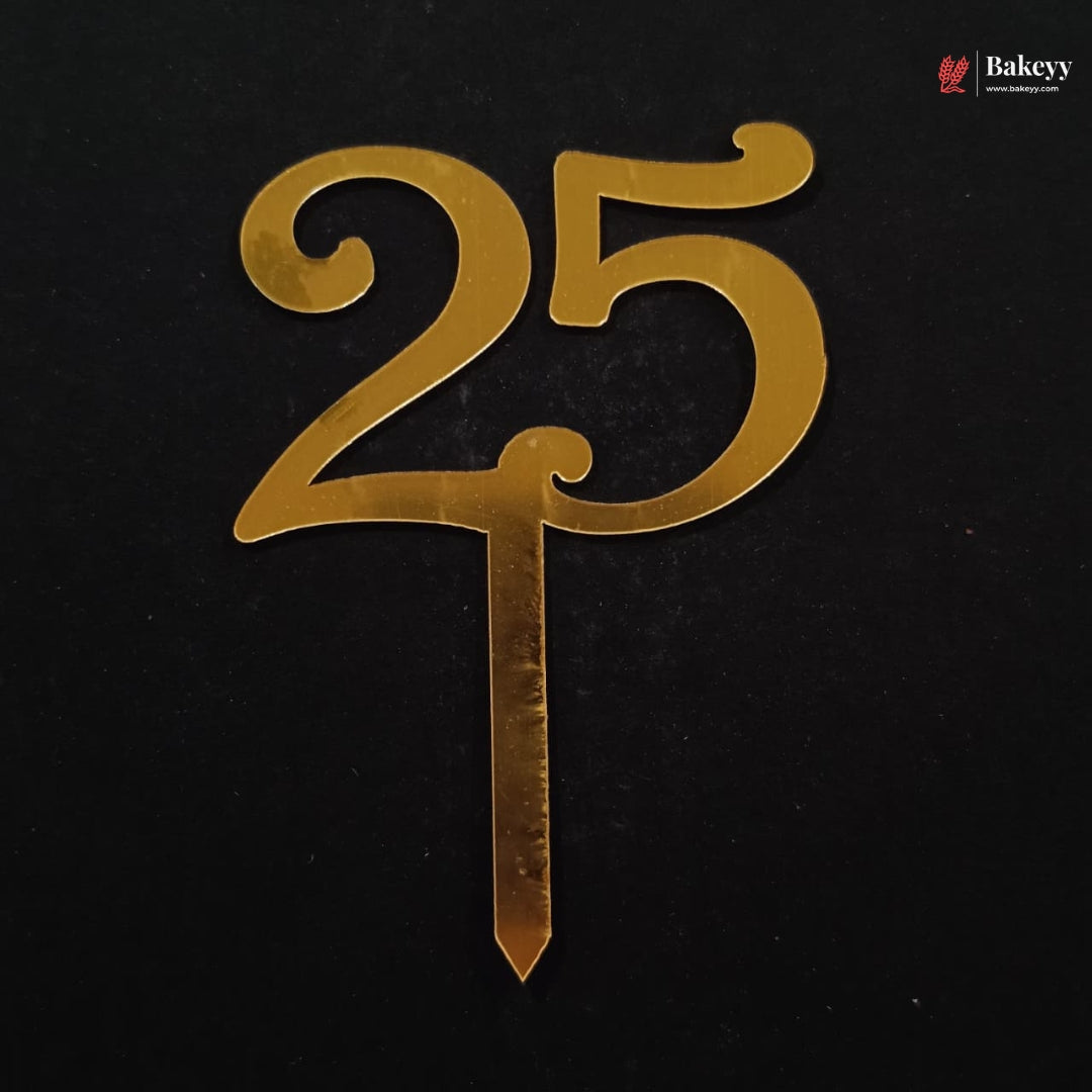 Gold metallic number 25 cake topper with a stick, shown on a black background. A Bakeey logo is visible in the top right corner.