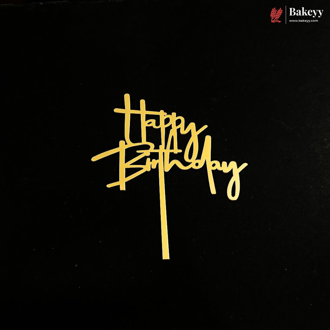 A gold foil 'Happy Birthday' script cake topper on a black background, with a Bakeyy brand logo in the top right corner.