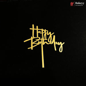 A gold foil 'Happy Birthday' script cake topper on a black background, with a Bakeyy brand logo in the top right corner.