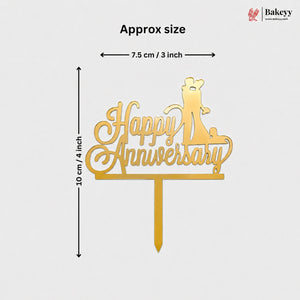Gold metal 'Happy Anniversary' cake topper with a cat silhouette, shown with dimension lines indicating approximately 10 cm in height and 7.5 cm in width on a light gray background.