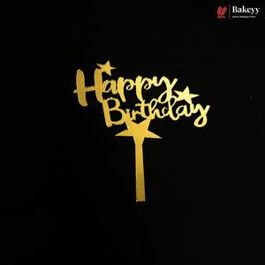 Gold 'Happy Birthday' cake topper with star accents and a stick, shown on a black background. A Bakeey logo is visible in the top right corner.
