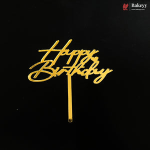 Gold metallic 'Happy Birthday' script cake topper on a black background, with a Bakeyy brand watermark in the top right corner.