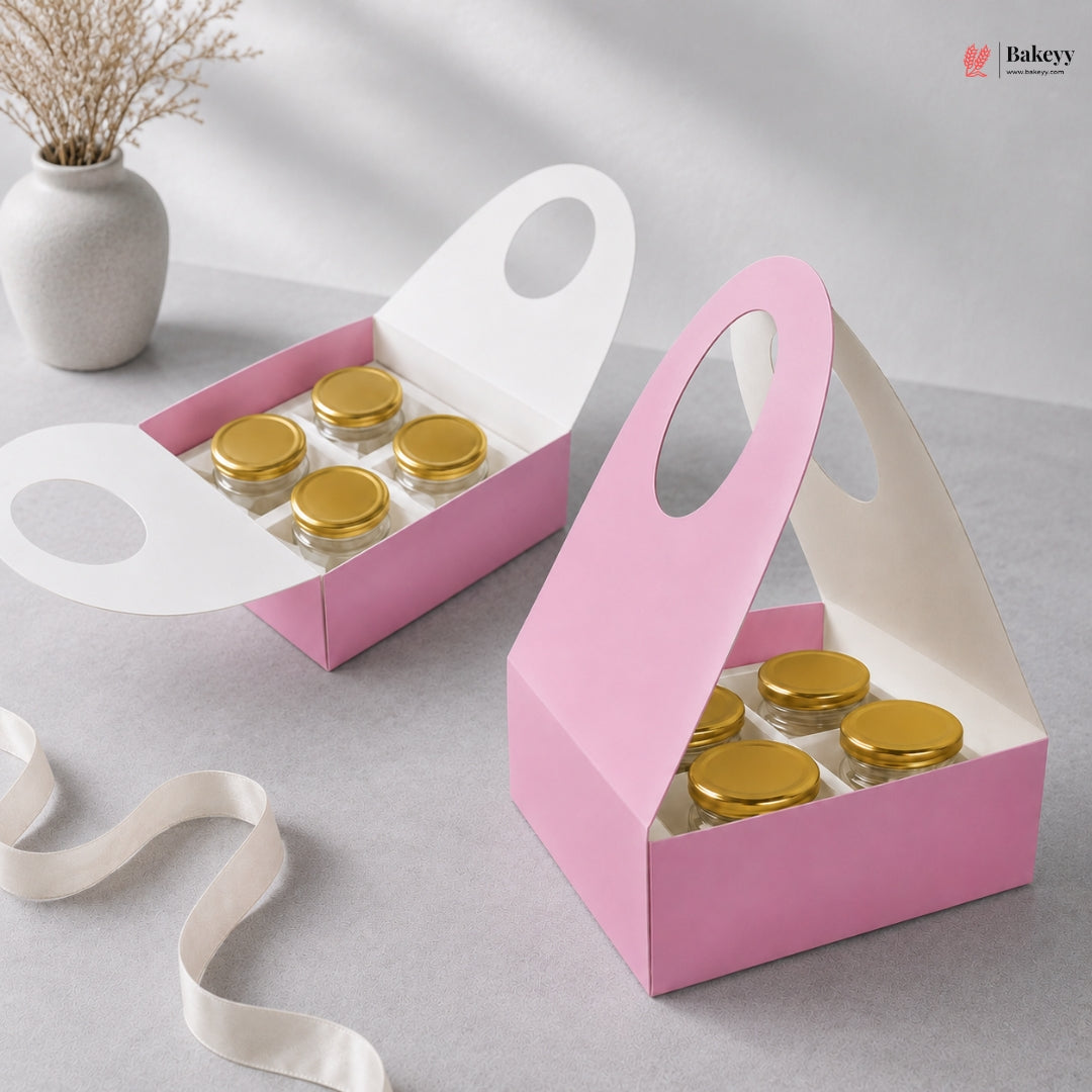 Pink packaging box with gold lids on a gray surface, featuring the Bakeyy brand.
