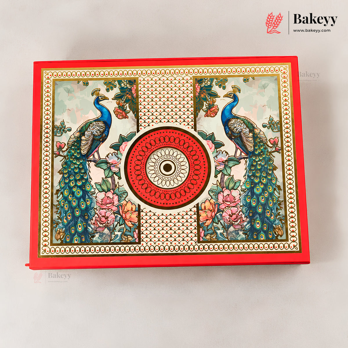 A decorative red rectangular box with ornate printed peacock and floral artwork, centered on a light neutral background. The box features a large circular red medallion motif in the middle and a repeating gold-toned border pattern.