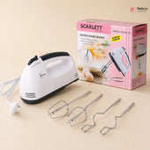 Scarlett hand mixer with attachments and packaging on a beige background