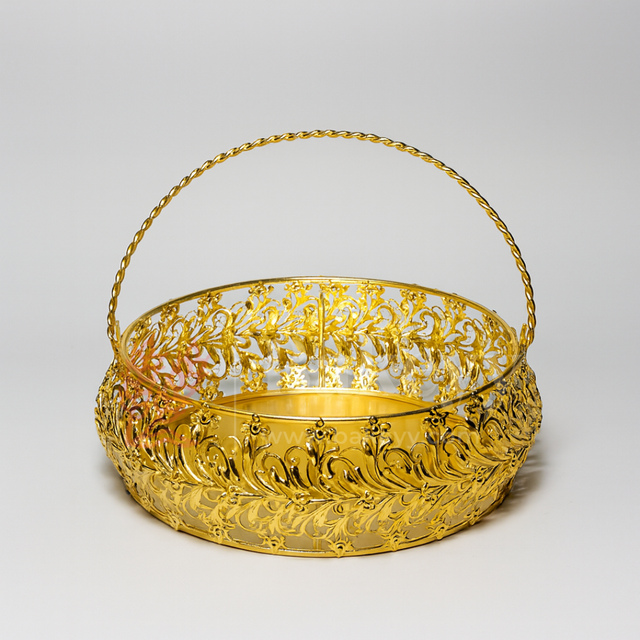 Gold decorative basket with intricate patterns on a light gray background