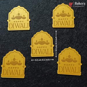 Five gold-colored arch-shaped Diwali-themed labels or stickers with 'HAPPY DIWALI' text and diya illustrations, arranged on a dark textured background with dimension arrows indicating 5.5 cm (2.